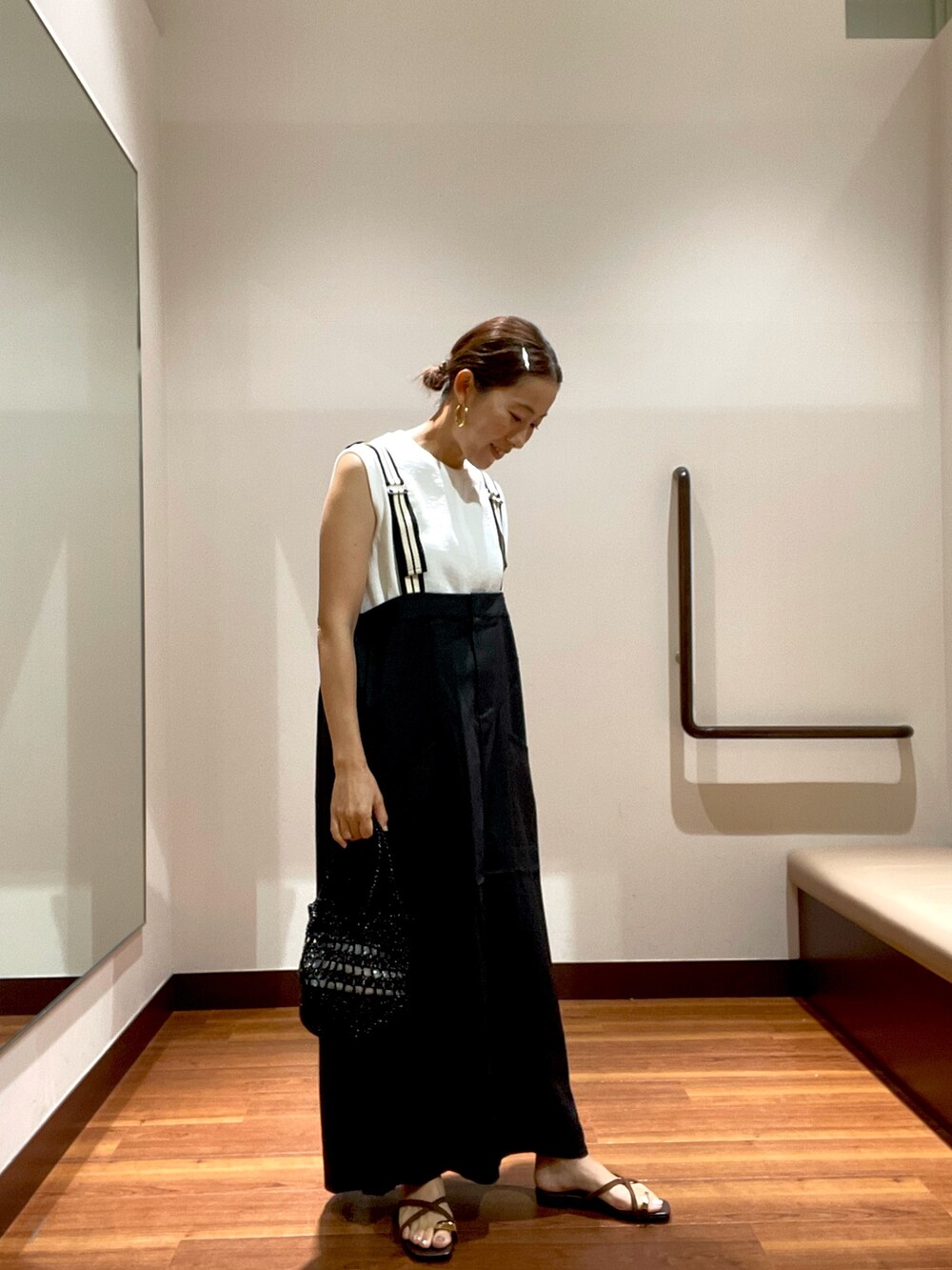 グレー系のワンピース、ホワイト系のTシャツ/カットソー、ブラック系のショルダーバッグを着用したレディースの夏コーディネートの3枚目の写真