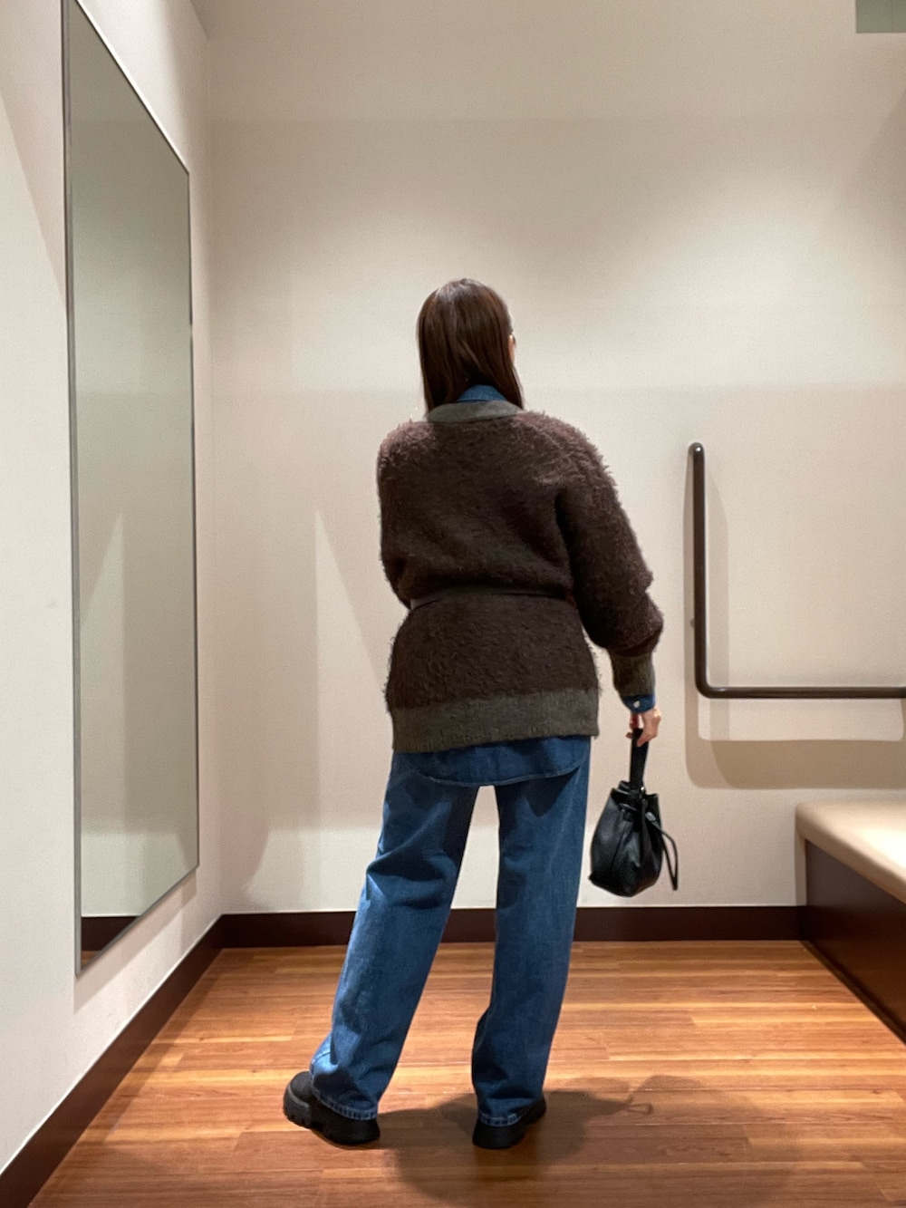 ブルー系のデニムパンツ、ブラウン系のカーディガン/ボレロ、ブルー系のシャツ/ブラウスを着用したレディースの秋コーディネートの3枚目の写真