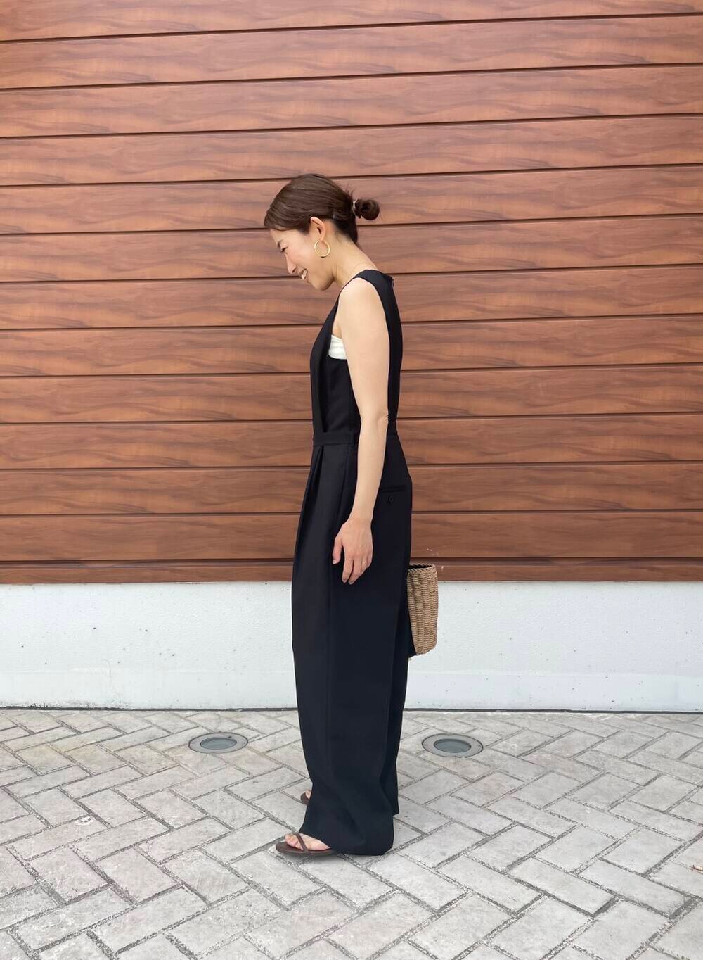 ブラウン系のサンダル、ブラック系のサロペット/オーバーオール、ベージュ系のハンドバッグを着用したレディースの夏コーディネートの2枚目の写真