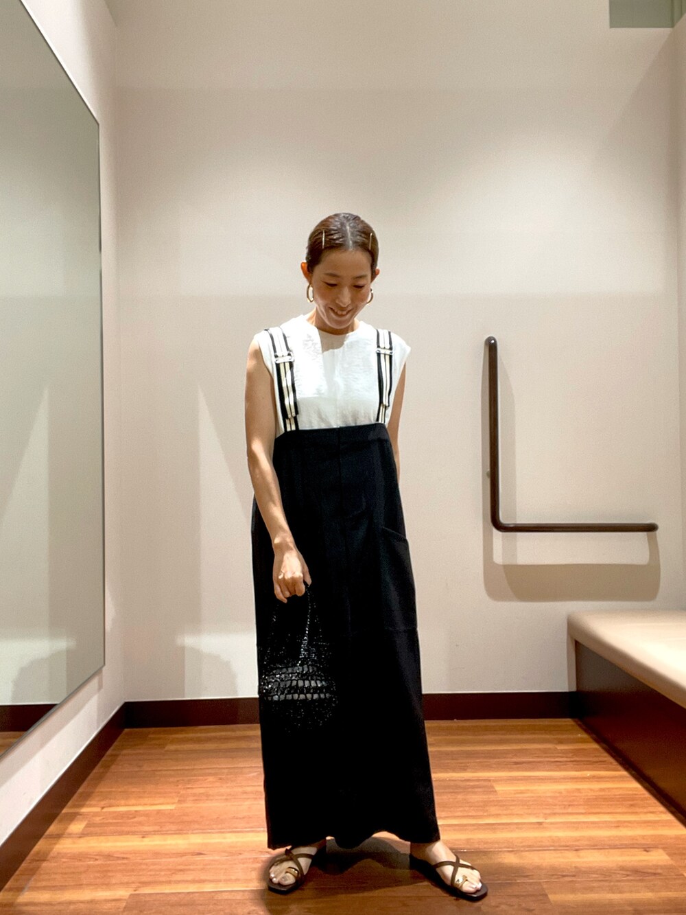 グレー系のワンピース、ホワイト系のTシャツ/カットソー、ブラック系のショルダーバッグを着用したレディースの夏コーディネートの2枚目の写真