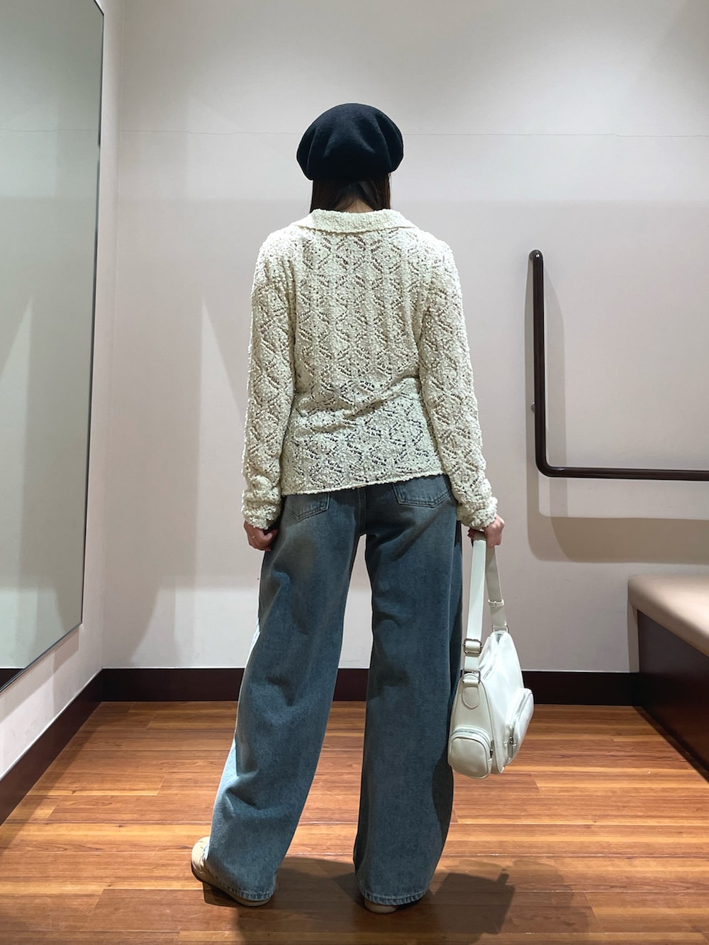 ブルー系のデニムパンツ、ホワイト系のショルダーバッグ、ホワイト系のニット/セーターを着用したレディースの春コーディネートの2枚目の写真