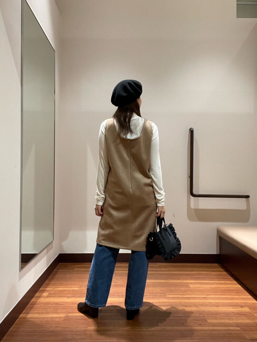 ホワイト系のTシャツ/カットソー、ブラック系のハンドバッグ、ベージュ系のワンピースを着用したレディースの秋コーディネートの4枚目の写真