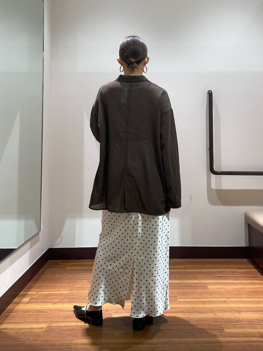 ブラウン系のその他アウター、ホワイト系のスカート、ブラック系のパンプスを着用したレディースの秋コーディネートの3枚目の写真