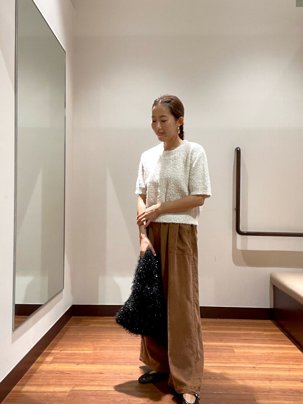 ホワイト系のニット/セーター、ブラウン系のその他パンツ、ブラック系のトートバッグを着用したレディースの秋コーディネートの2枚目の写真