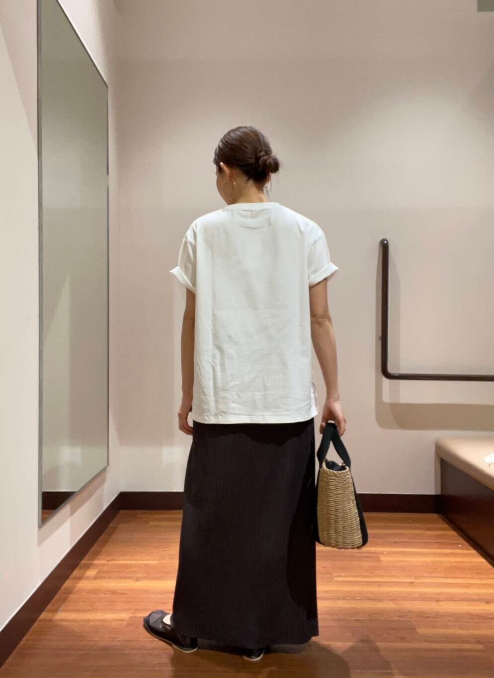 ベージュ系のハンドバッグ、ホワイト系のTシャツ/カットソー、ブラック系のその他シューズを着用したレディースの夏コーディネートの5枚目の写真