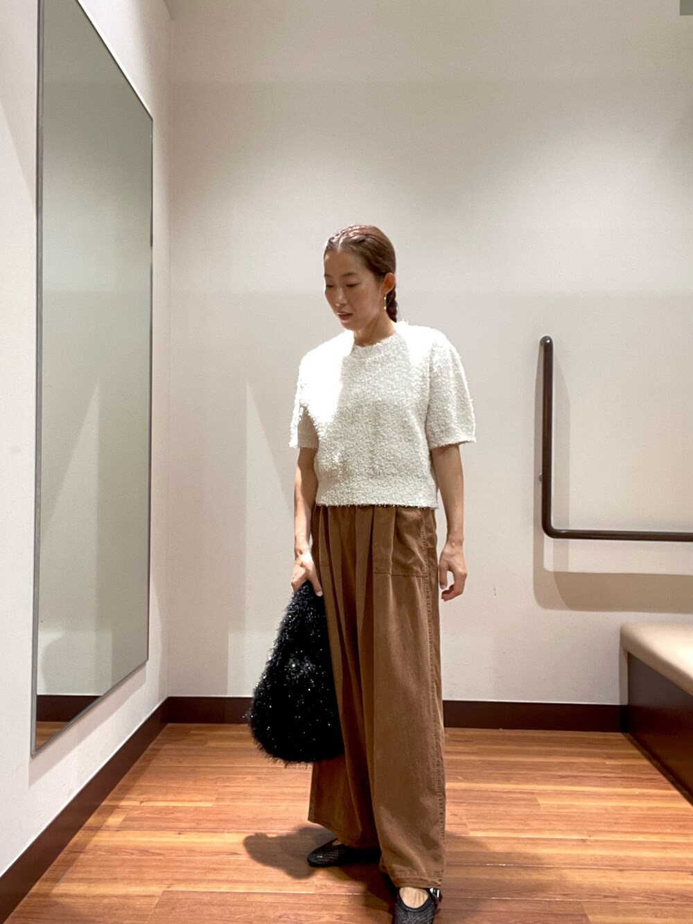 ホワイト系のニット/セーター、ブラウン系のその他パンツ、ブラック系のトートバッグを着用したレディースの秋コーディネートの3枚目の写真