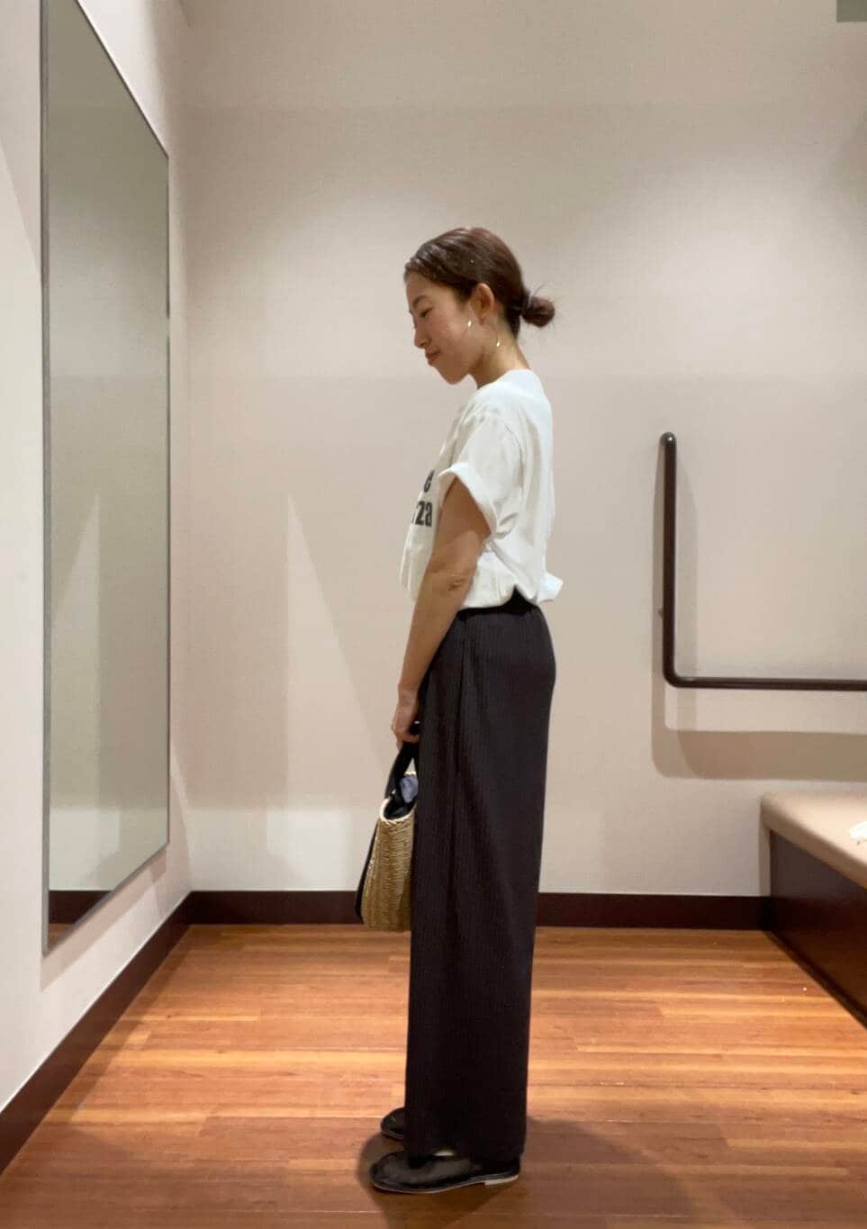 ベージュ系のハンドバッグ、ホワイト系のTシャツ/カットソー、ブラック系のその他シューズを着用したレディースの夏コーディネートの2枚目の写真