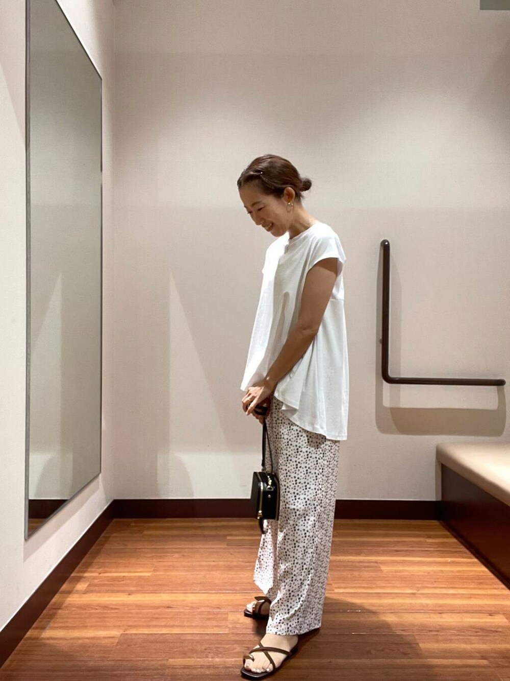 ホワイト系のTシャツ/カットソー、ホワイト系のその他パンツ、ブラック系のショルダーバッグを着用したレディースの夏コーディネートの2枚目の写真