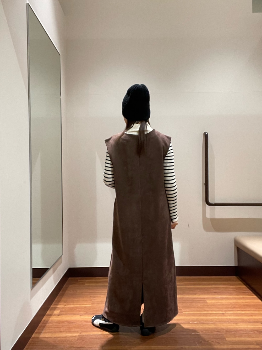 ブラウン系のワンピース、その他のニット/セーター、ブラック系のスニーカーを着用したレディースの冬コーディネートの3枚目の写真