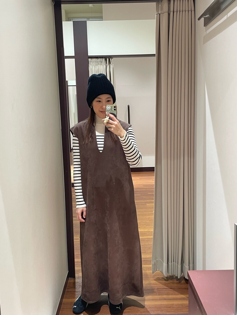 ブラウン系のワンピース、その他のニット/セーター、ブラック系のスニーカーを着用したレディースの冬コーディネートの4枚目の写真