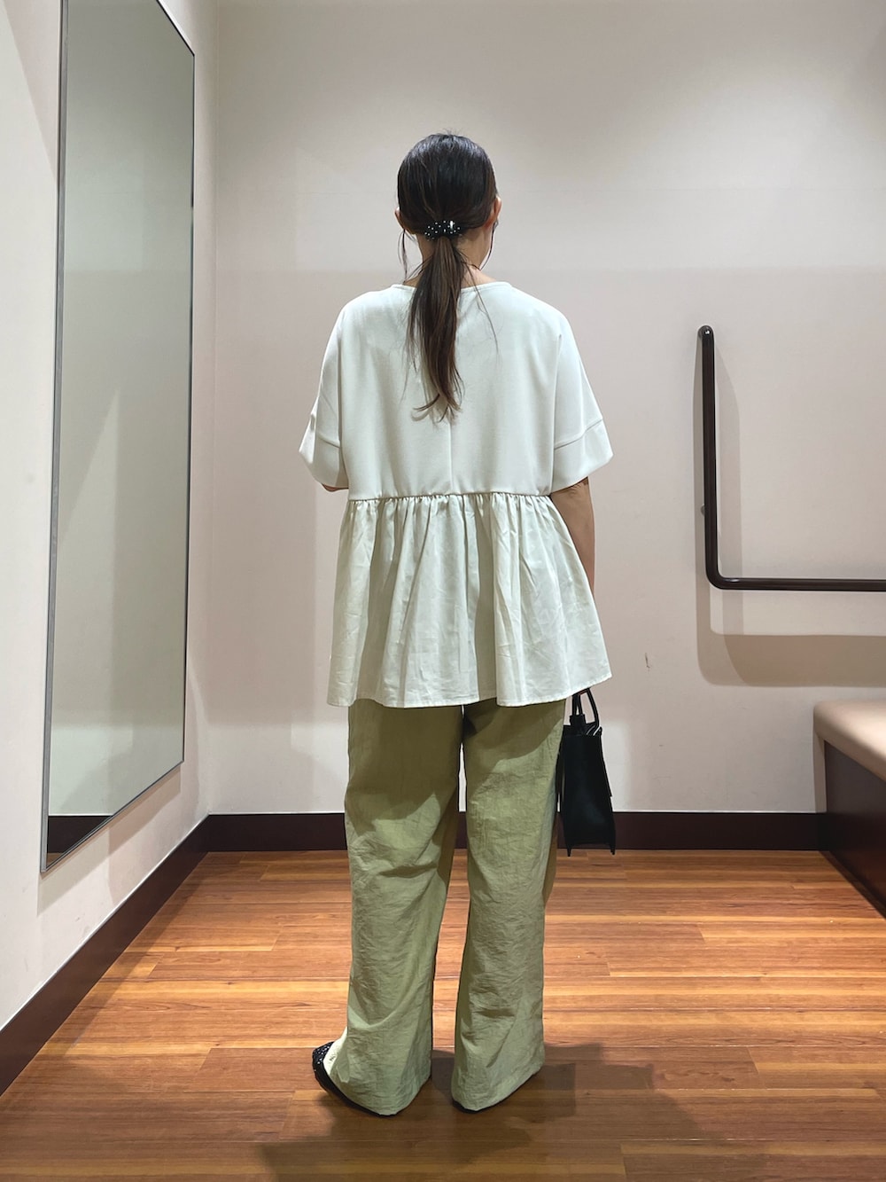 ホワイト系のTシャツ/カットソー、ブラック系のハンドバッグ、ブラック系のバレエシューズを着用したレディースの春コーディネートの2枚目の写真