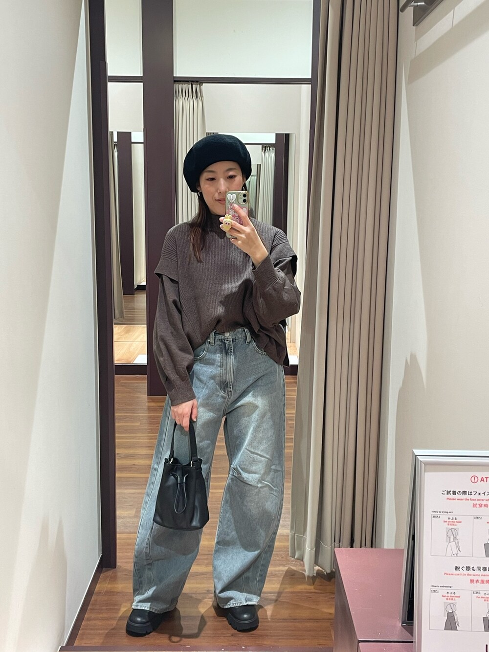 ブラウン系のニット/セーター、ブルー系のデニムパンツ、ブラック系のショルダーバッグを着用したレディースの冬コーディネートの3枚目の写真