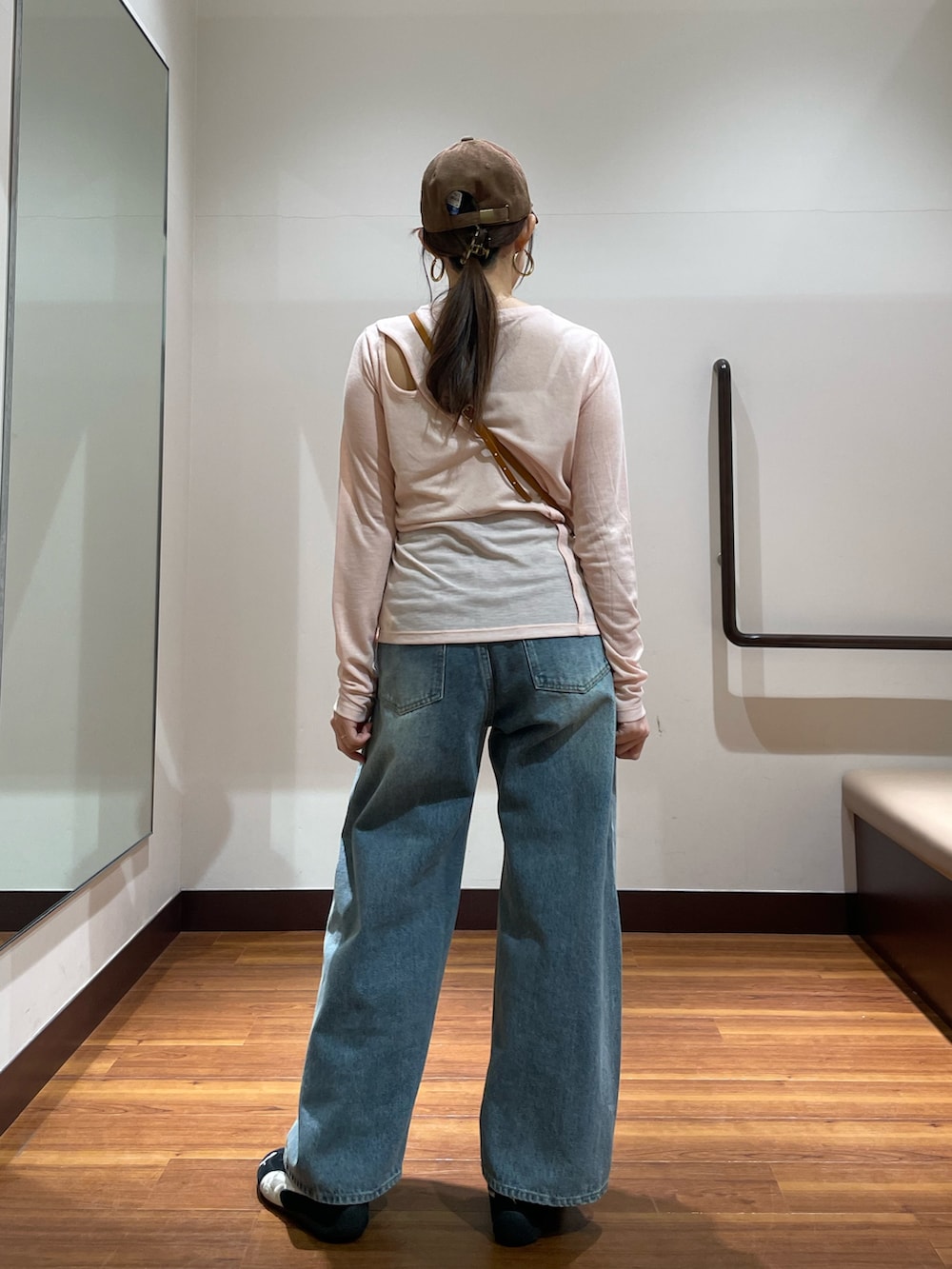 イエロー系のショルダーバッグ、ピンク系のTシャツ/カットソー、ブルー系のデニムパンツを着用したレディースの春コーディネートの2枚目の写真