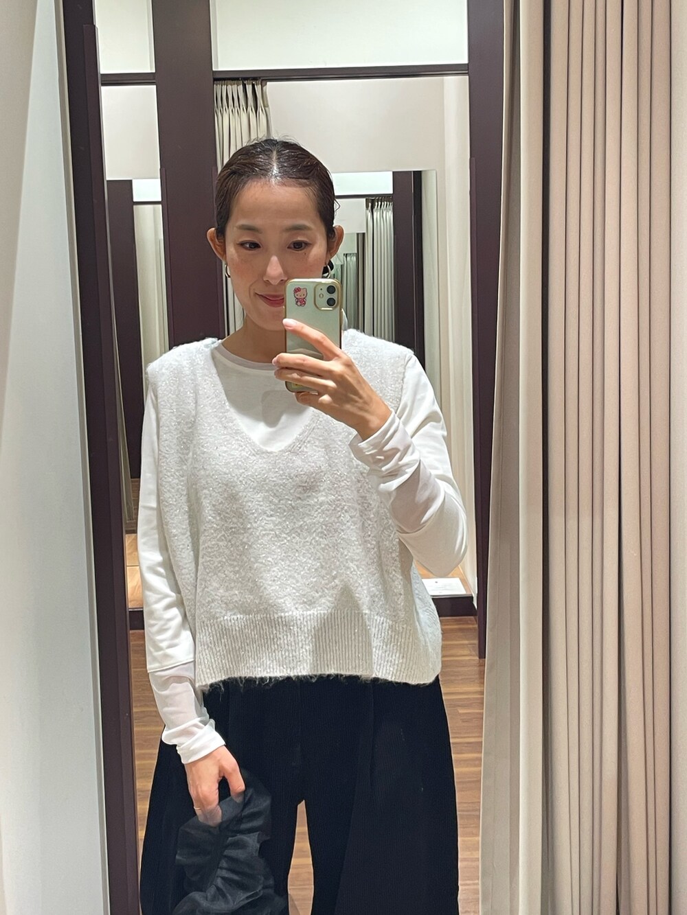 ホワイト系のニット/セーター、ホワイト系のTシャツ/カットソー、ブラック系のローファーを着用したレディースの秋コーディネートの4枚目の写真