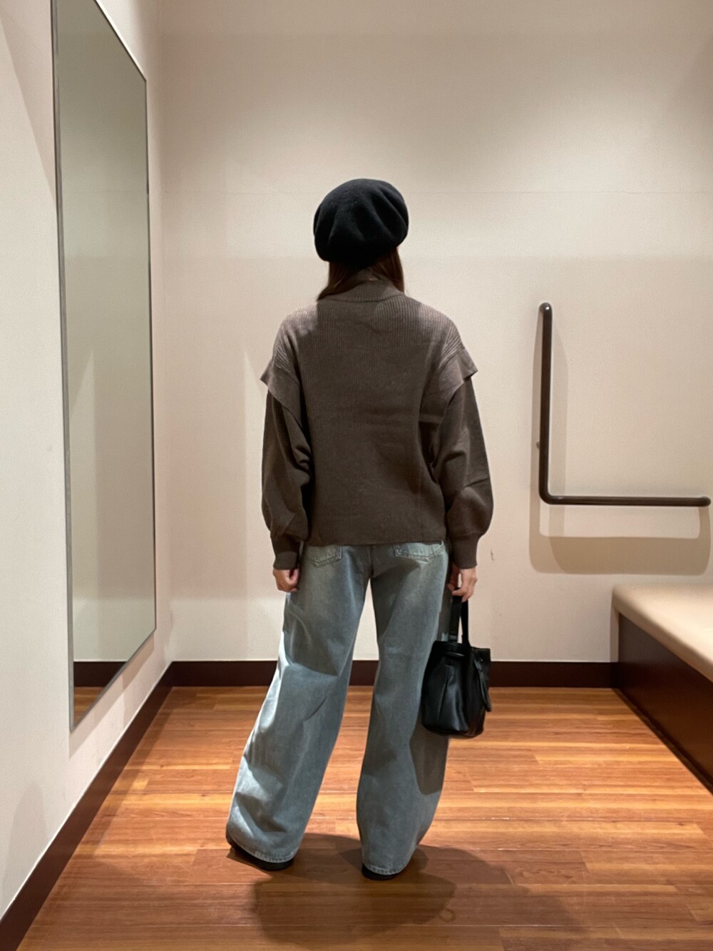 ブラウン系のニット/セーター、ブルー系のデニムパンツ、ブラック系のショルダーバッグを着用したレディースの冬コーディネートの2枚目の写真