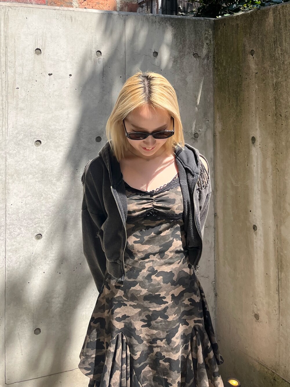 ブラック系のパーカー、ブラック系のブーツ、グリーン系のワンピースを着用したレディースの春コーディネートの4枚目の写真