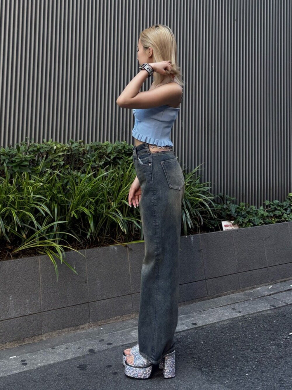 シルバー系のサンダル、ブルー系のキャミソール、ブルー系のデニムパンツを着用したレディースの夏コーディネートの2枚目の写真