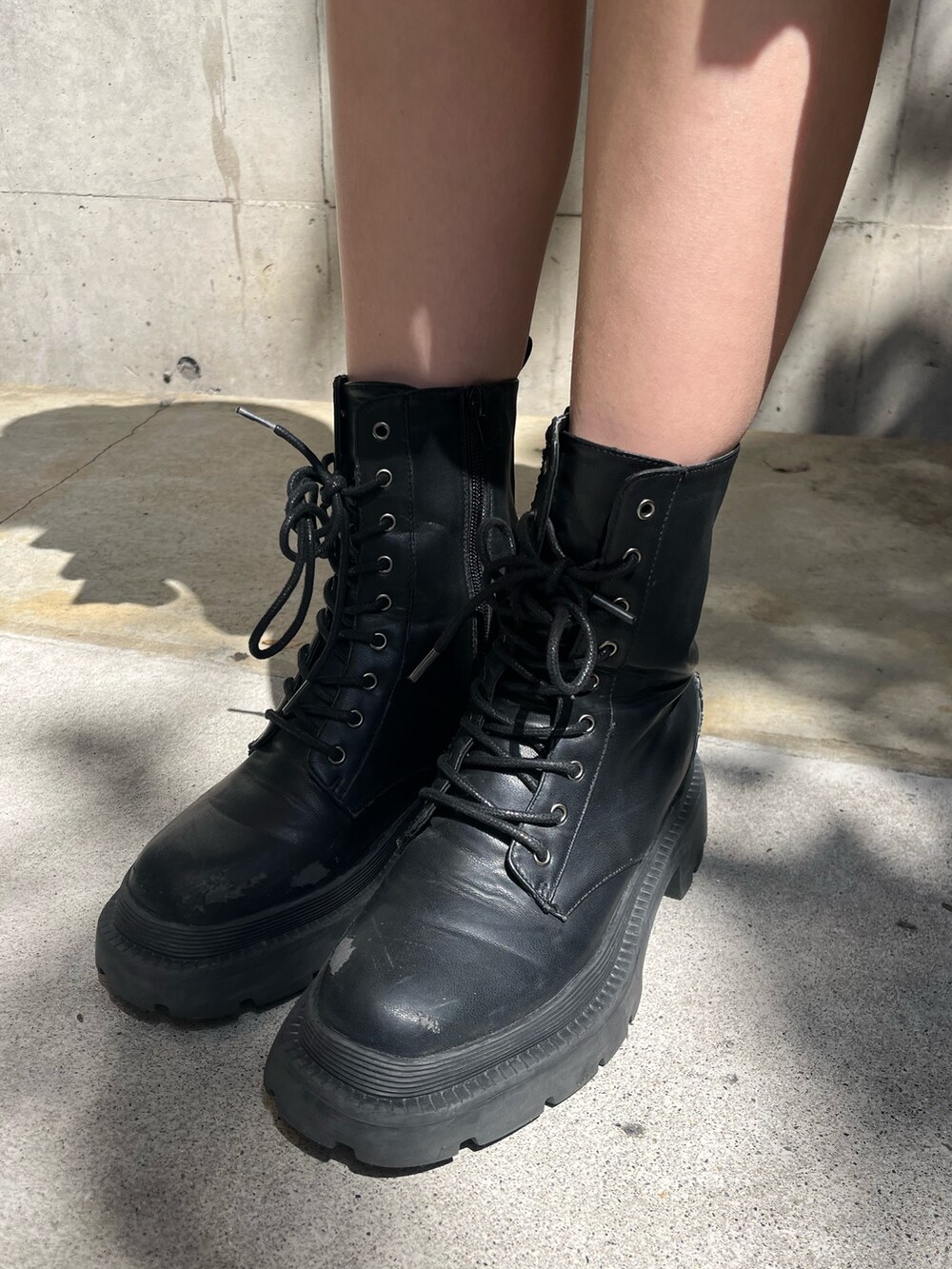 ブラック系のパーカー、ブラック系のブーツ、グリーン系のワンピースを着用したレディースの春コーディネートの7枚目の写真