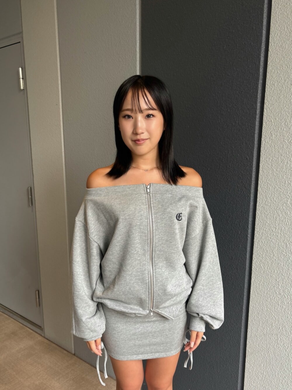 ブラック系のブーツ、グレー系のパーカー、グレー系のスカートを着用したレディースの秋コーディネートの5枚目の写真