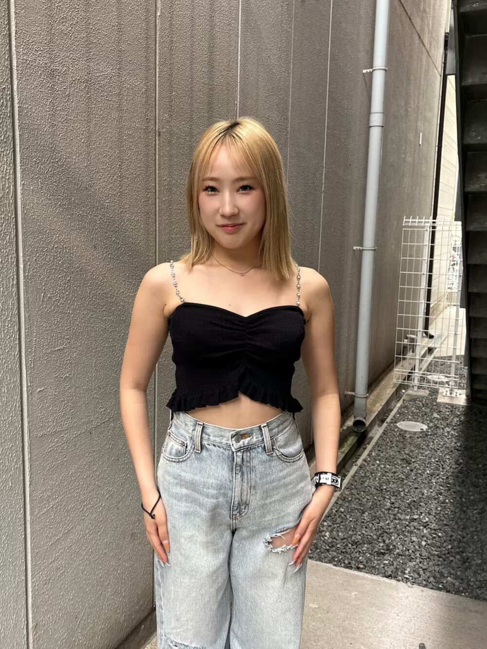 ブラック系のキャミソール、ブルー系のデニムパンツ、シルバー系のサンダルを着用したレディースの夏コーディネートの4枚目の写真