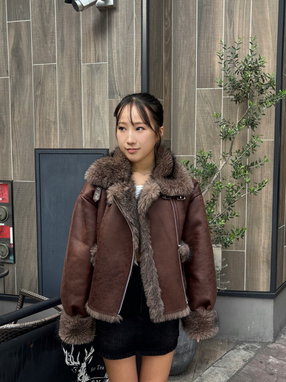 ホワイト系のTシャツ/カットソー、ブラック系のブーツ、ブラック系のデニムスカートを着用したレディースの秋コーディネートの4枚目の写真