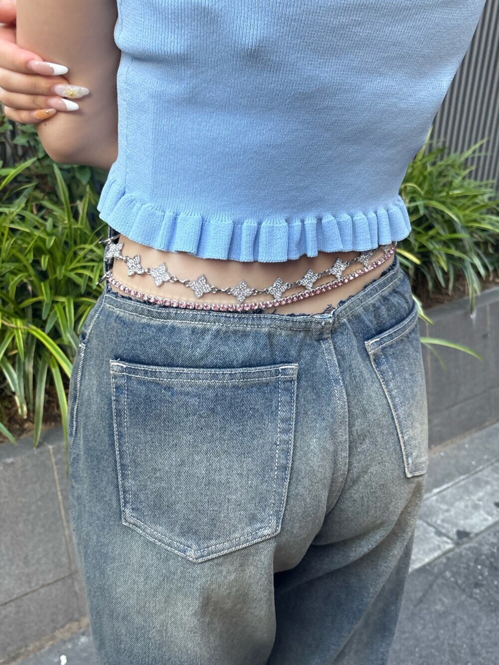 シルバー系のサンダル、ブルー系のキャミソール、ブルー系のデニムパンツを着用したレディースの夏コーディネートの6枚目の写真