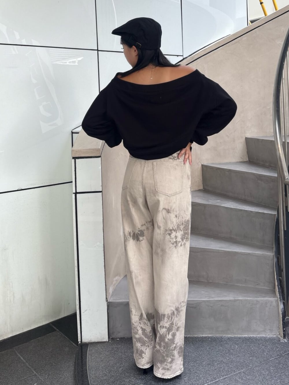 グレー系のパーカー、ブラック系のパンプス、ブラック系のデニムパンツを着用したレディースの秋コーディネートの3枚目の写真