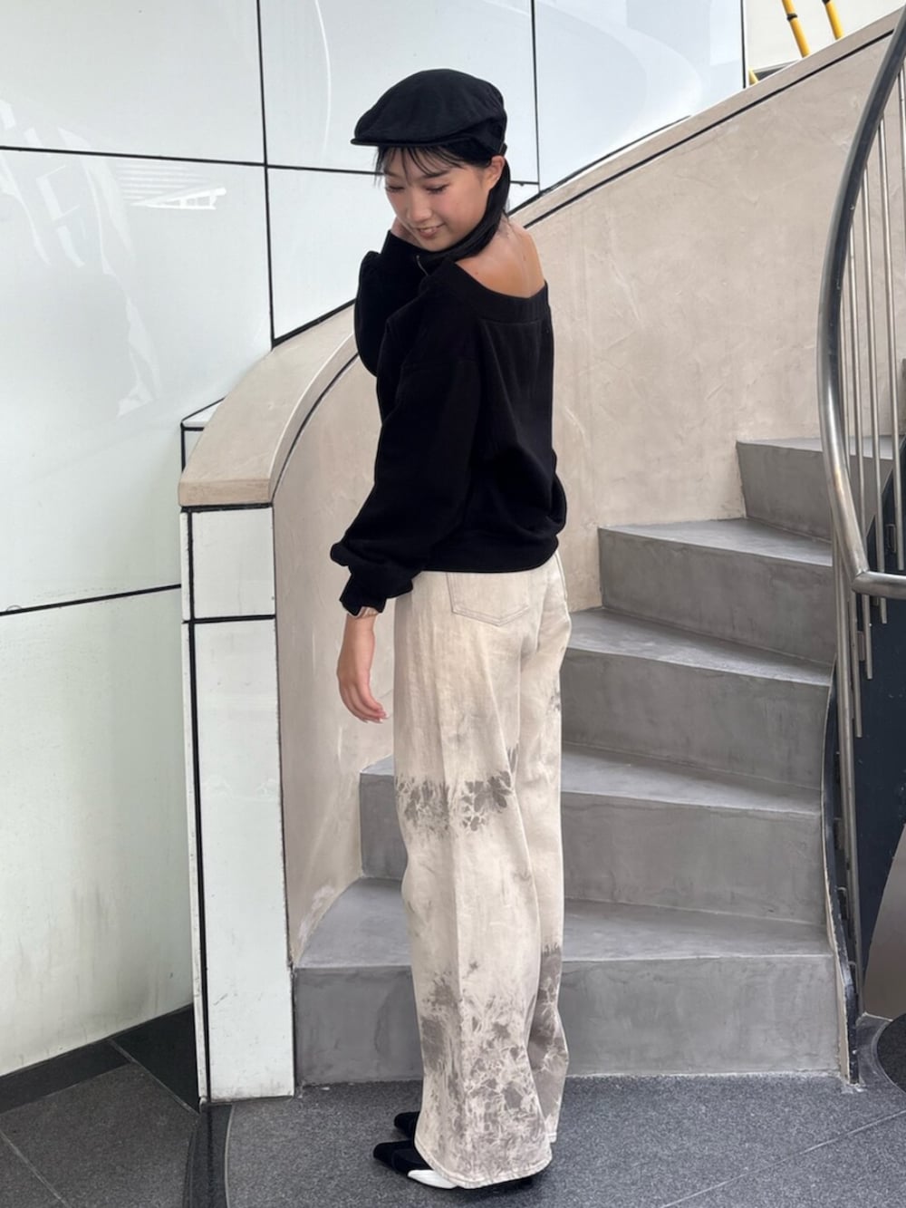 グレー系のパーカー、ブラック系のパンプス、ブラック系のデニムパンツを着用したレディースの秋コーディネートの2枚目の写真