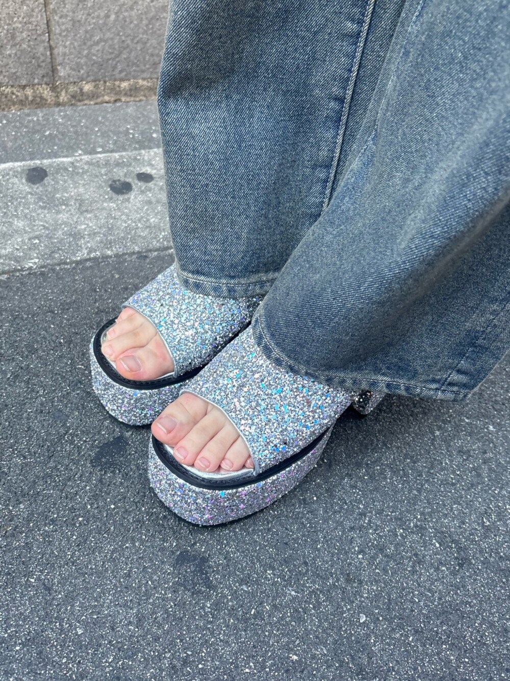 シルバー系のサンダル、ブルー系のキャミソール、ブルー系のデニムパンツを着用したレディースの夏コーディネートの7枚目の写真