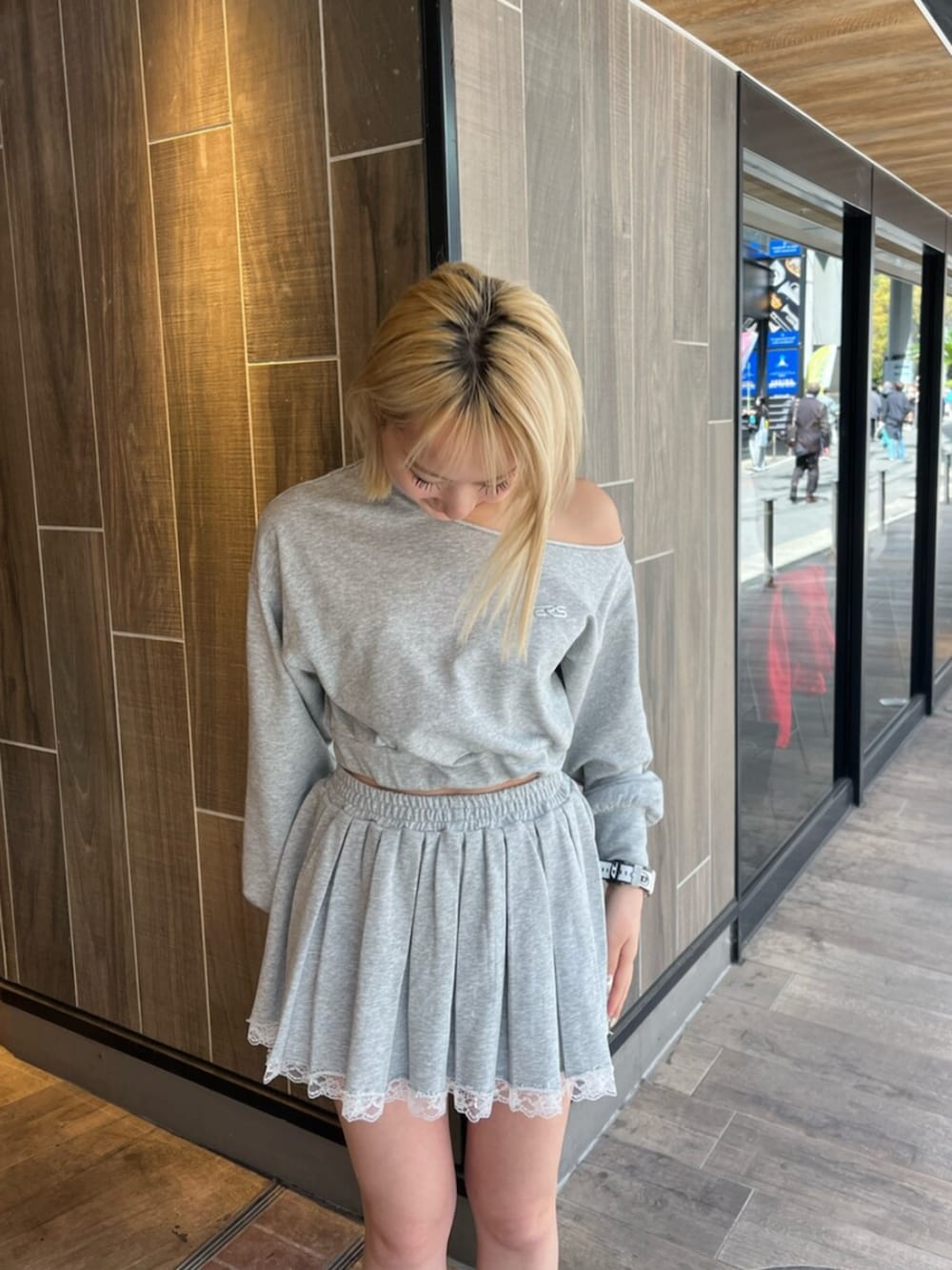 グレー系のスウェット、グレー系のスカート、ブラック系のブーツを着用したレディースの春コーディネートの4枚目の写真