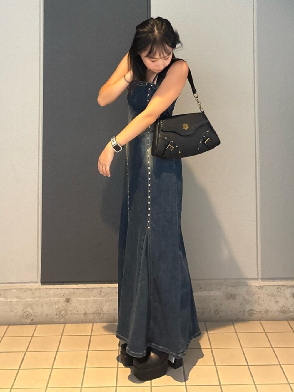 ブルー系のワンピース、ブラック系のハンドバッグ、ブラック系のブーツを着用したレディースの夏コーディネートの2枚目の写真