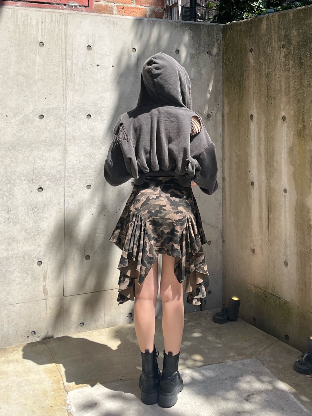 ブラック系のパーカー、ブラック系のブーツ、グリーン系のワンピースを着用したレディースの春コーディネートの3枚目の写真