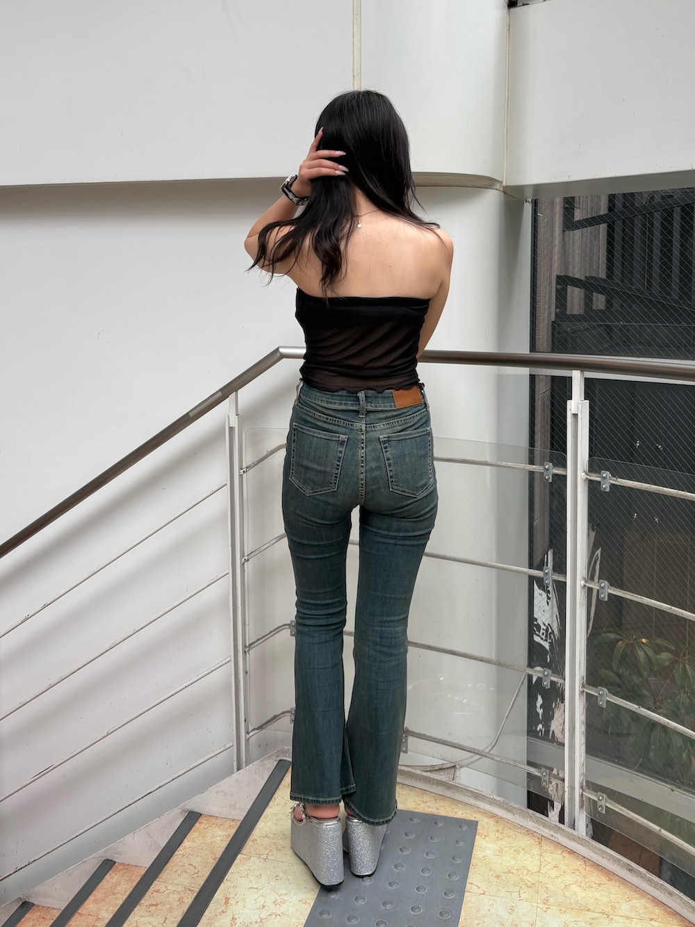 ベージュ系のキャミソール、ブルー系のデニムパンツ、シルバー系のサンダルを着用したレディースの夏コーディネートの3枚目の写真