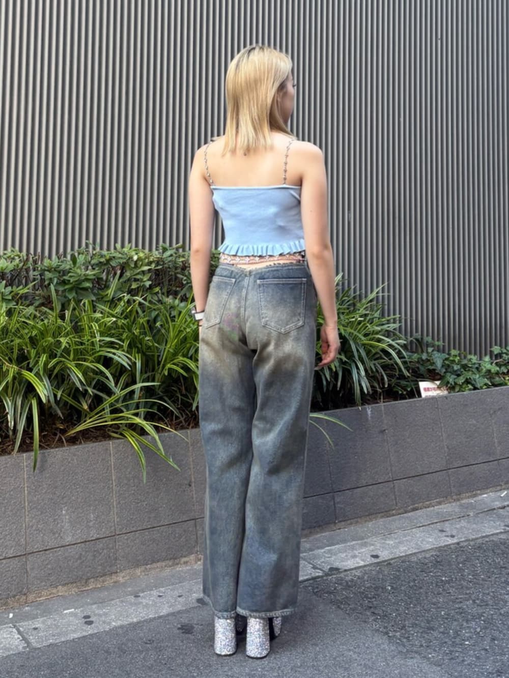 シルバー系のサンダル、ブルー系のキャミソール、ブルー系のデニムパンツを着用したレディースの夏コーディネートの3枚目の写真