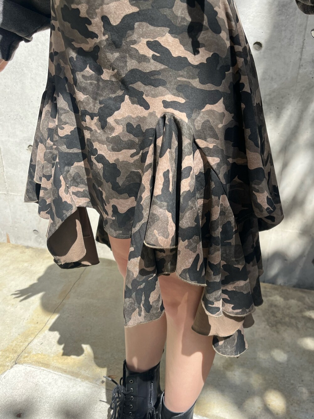 ブラック系のパーカー、ブラック系のブーツ、グリーン系のワンピースを着用したレディースの春コーディネートの5枚目の写真