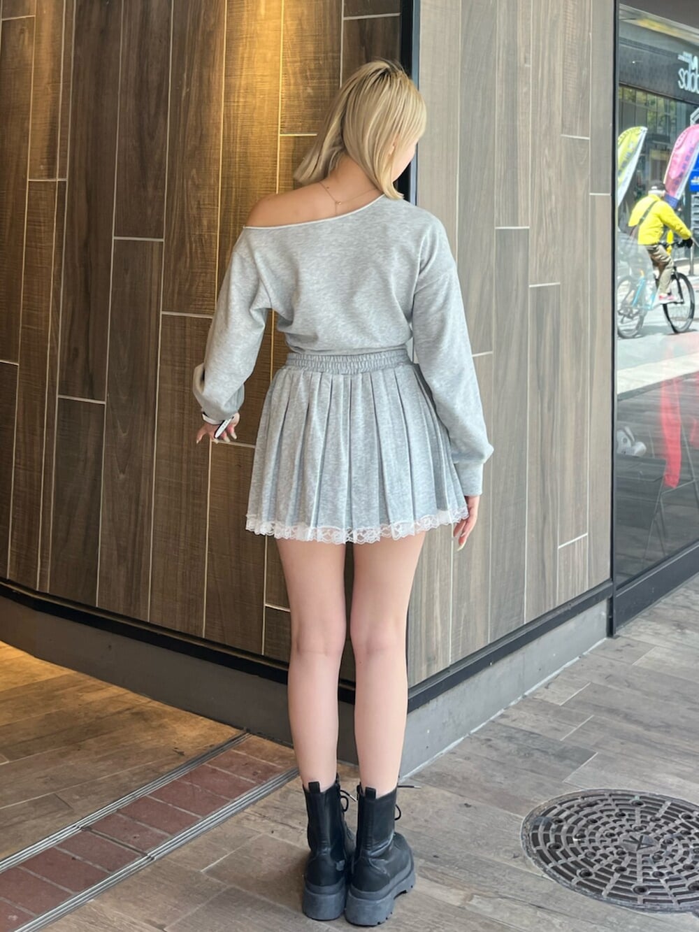 グレー系のスウェット、グレー系のスカート、ブラック系のブーツを着用したレディースの春コーディネートの3枚目の写真