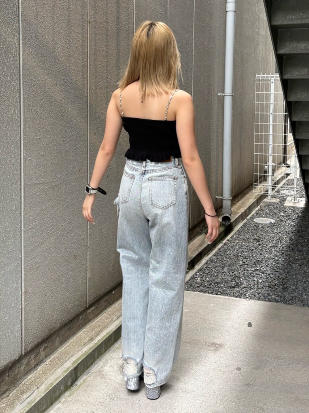 ブラック系のキャミソール、ブルー系のデニムパンツ、シルバー系のサンダルを着用したレディースの夏コーディネートの3枚目の写真