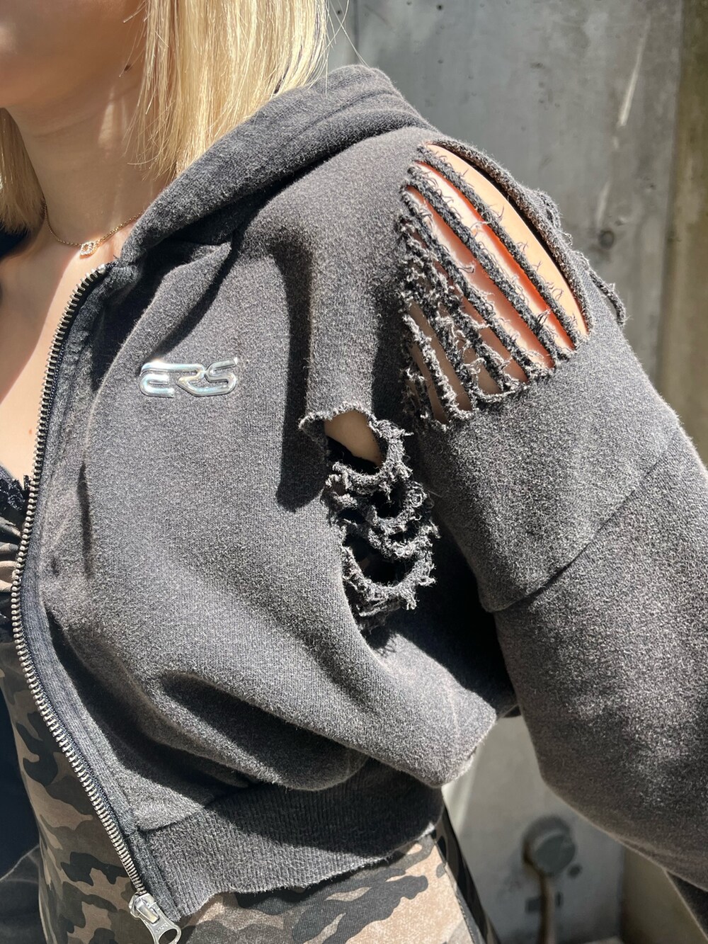 ブラック系のパーカー、ブラック系のブーツ、グリーン系のワンピースを着用したレディースの春コーディネートの6枚目の写真