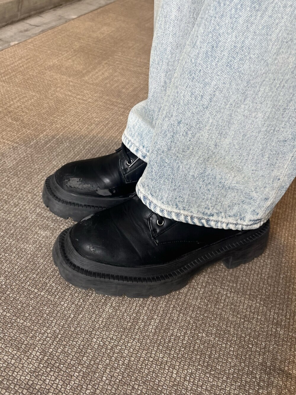 ブラック系のブーツ、グレー系のキャミソール、ブルー系のデニムパンツを着用したレディースの春コーディネートの7枚目の写真