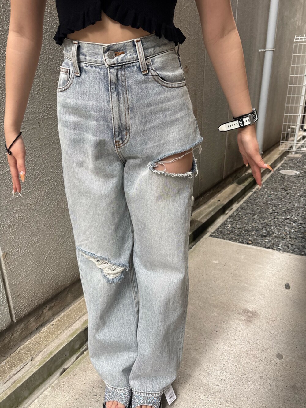 ブラック系のキャミソール、ブルー系のデニムパンツ、シルバー系のサンダルを着用したレディースの夏コーディネートの6枚目の写真