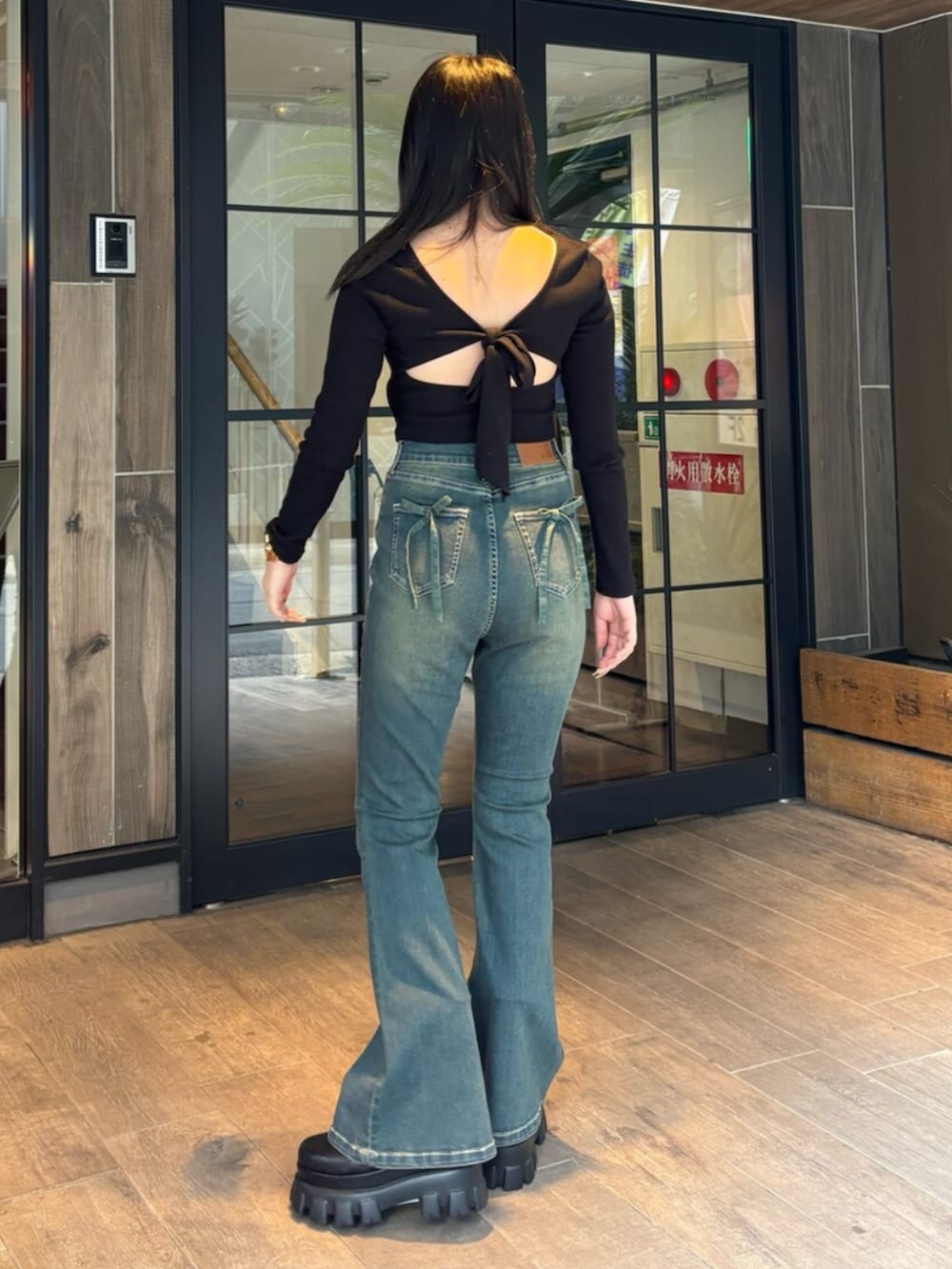 ブルー系のデニムパンツ、ブラック系のブーツ、ブラック系のTシャツ/カットソーを着用したレディースの春コーディネートの3枚目の写真