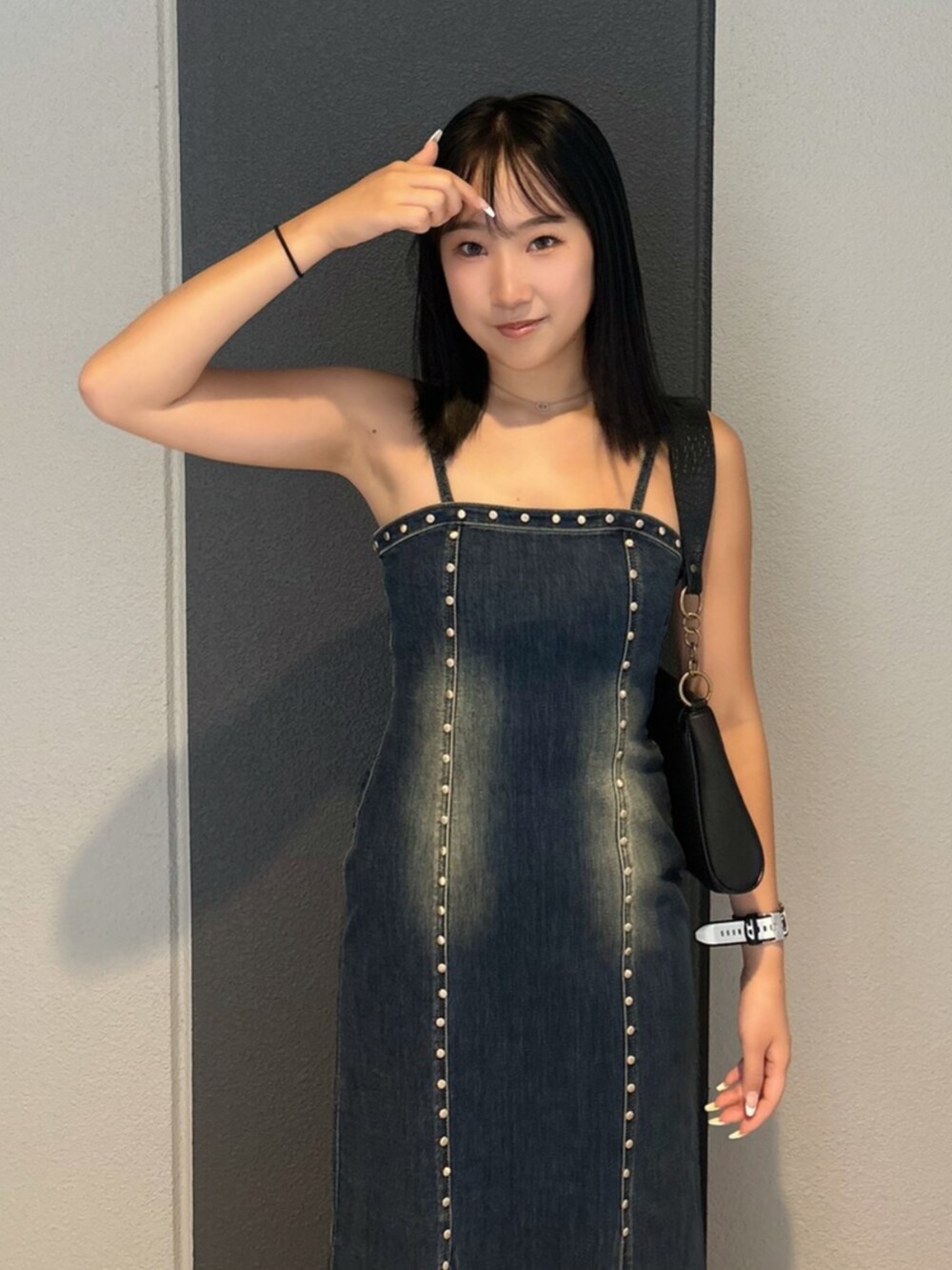 ブルー系のワンピース、ブラック系のハンドバッグ、ブラック系のブーツを着用したレディースの夏コーディネートの4枚目の写真