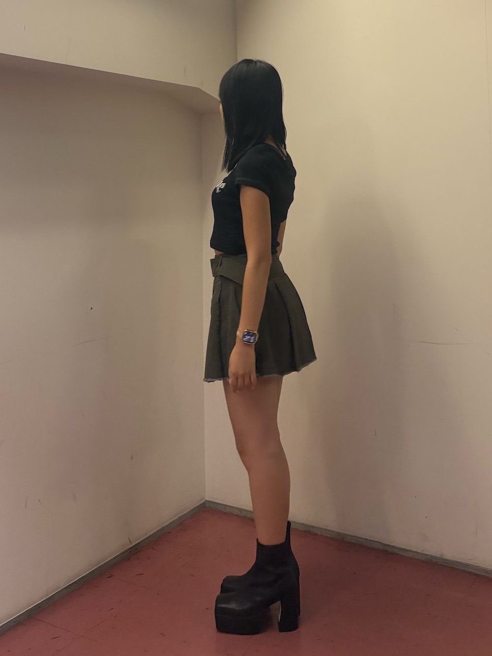 グレー系のスカート、ブラック系のTシャツ/カットソー、ブラック系のブーツを着用したレディースの夏コーディネートの2枚目の写真