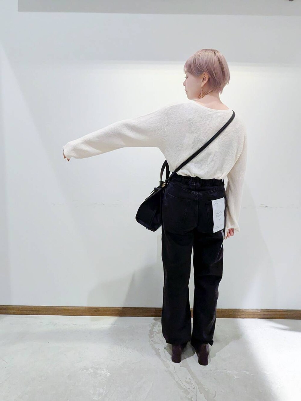 ブラック系のローファー、ブラック系のショルダーバッグ、ブルー系のデニムパンツを着用したレディースの秋コーディネートの3枚目の写真