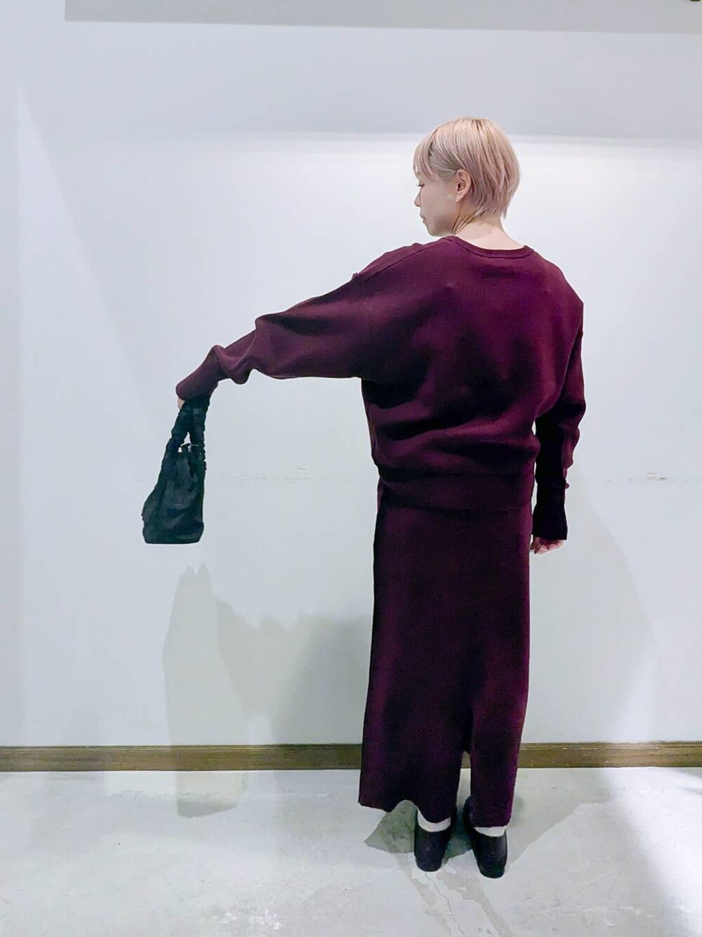 ブラウン系のローファー、ブラック系のショルダーバッグ、レッド系のニット/セーターを着用したレディースの秋コーディネートの3枚目の写真