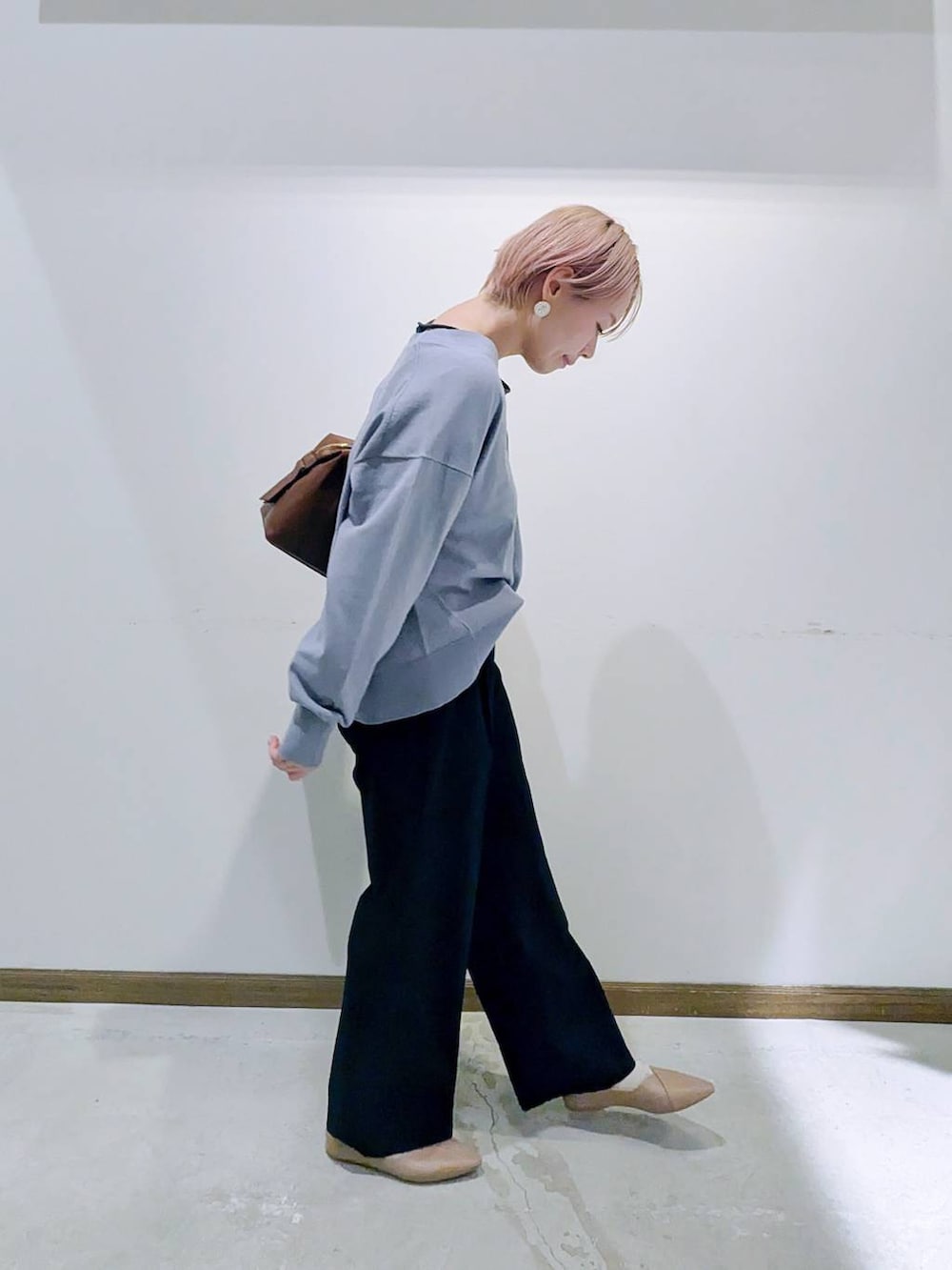 ベージュ系のパンプス、ブラウン系のボストンバッグ、ブルー系のカーディガン/ボレロを着用したレディースの秋コーディネートの2枚目の写真