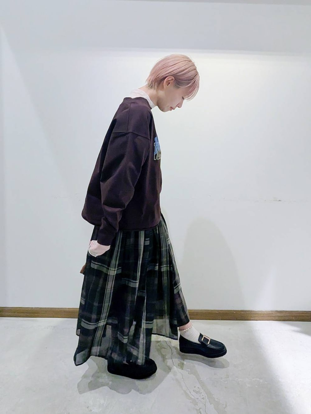 ブラック系のローファー、ブラック系のスカート、ブラック系のトートバッグを着用したレディースの秋コーディネートの2枚目の写真