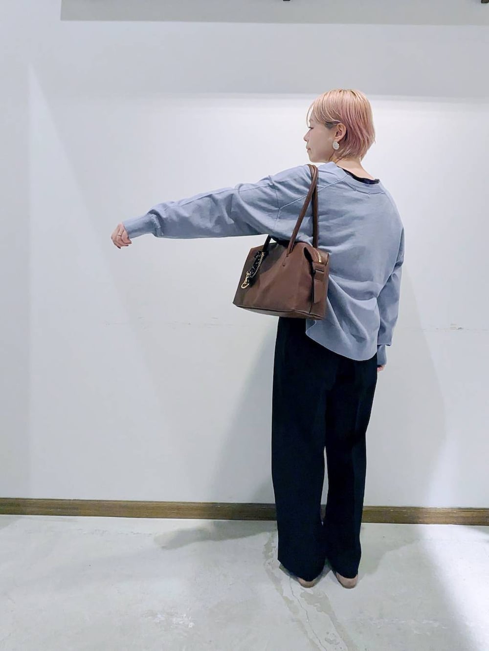 ベージュ系のパンプス、ブラウン系のボストンバッグ、ブルー系のカーディガン/ボレロを着用したレディースの秋コーディネートの3枚目の写真