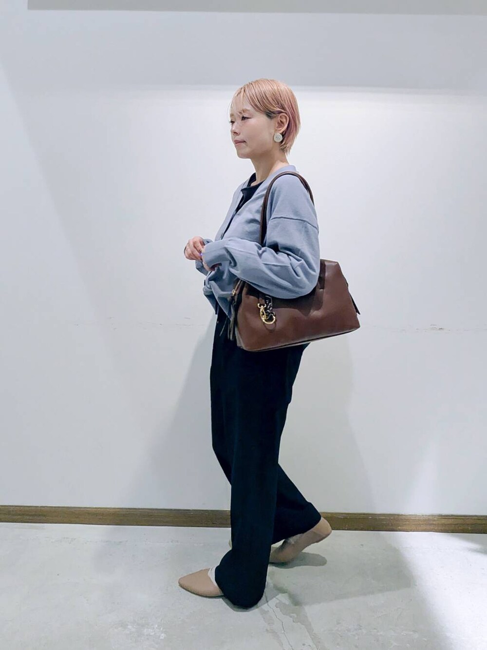 ベージュ系のパンプス、ブラウン系のボストンバッグ、ブルー系のカーディガン/ボレロを着用したレディースの秋コーディネートの4枚目の写真