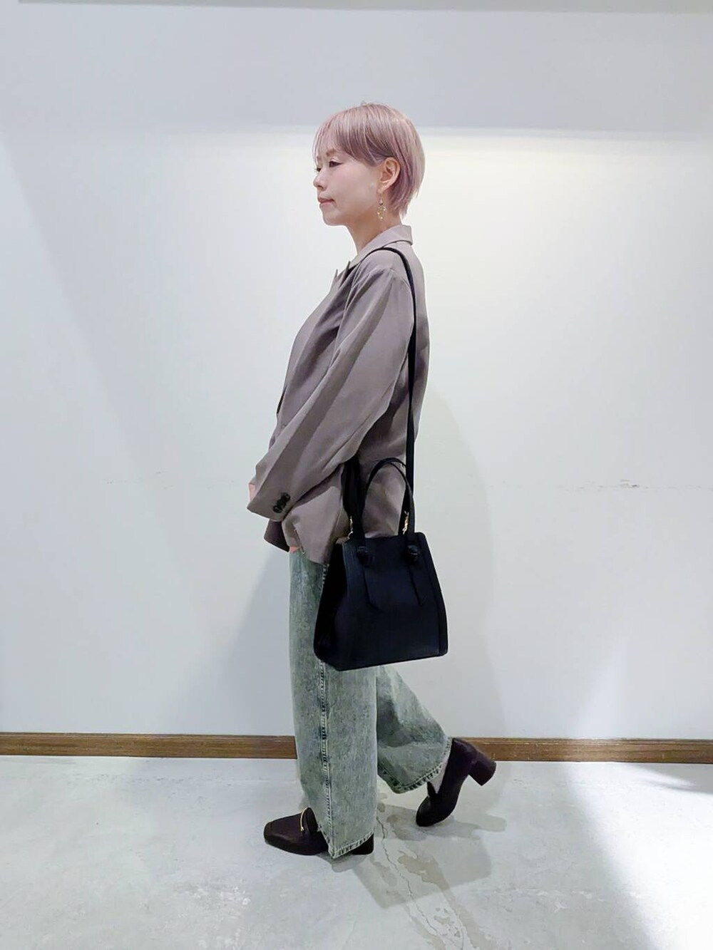 ブラック系のローファー、ブラック系のショルダーバッグ、ブラウン系のキャミソールを着用したレディースの秋コーディネートの4枚目の写真